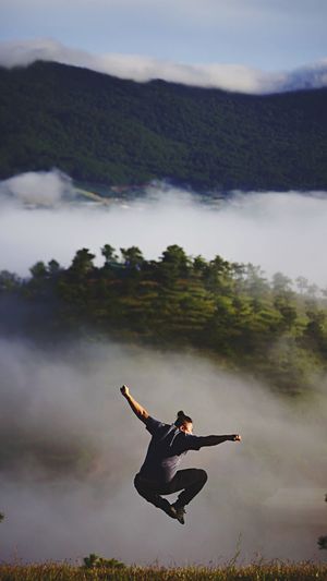 Woman climbing on mountain against sky