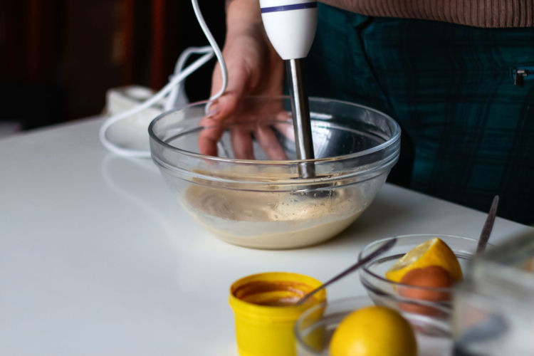 Beating of homemade mayonnaise with olive oil. mix ingredients for sauce. the chef uses a blender. 