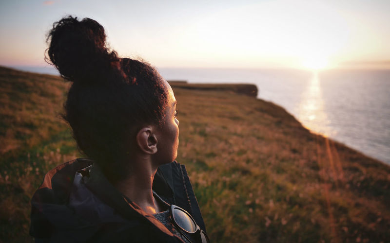 Woman looking at sea during sunset