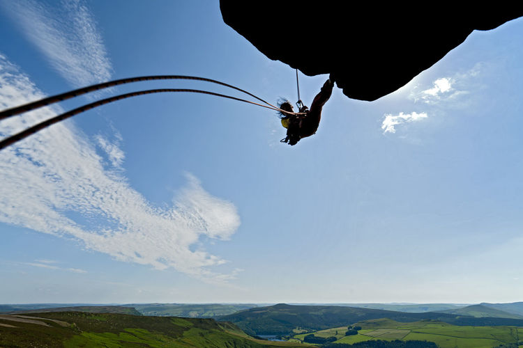 Woman rappelling from cliff at windgather rocks in the peak district