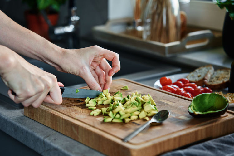 Cropped hands of person preparing food on cutting board