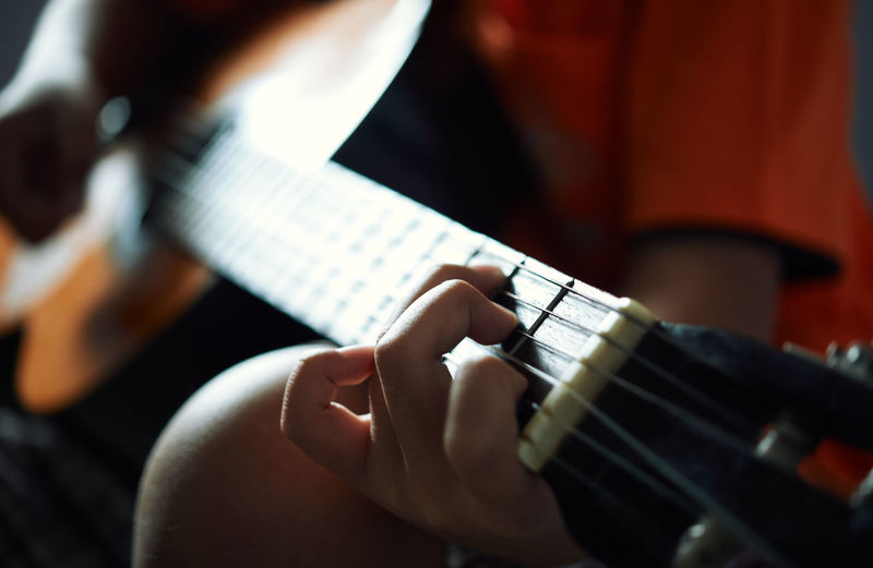 Close-up view of finger and guitar chord