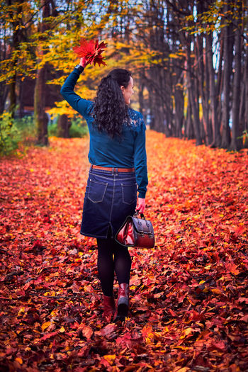 Full length of woman with autumn leaves