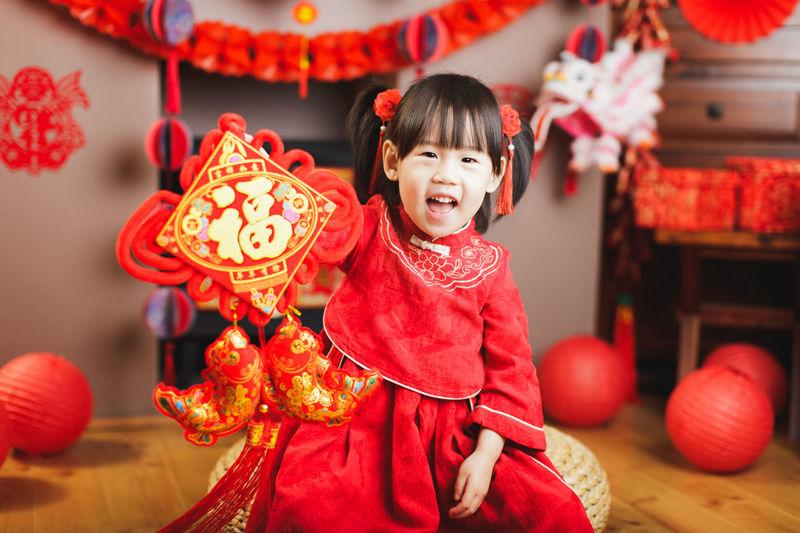 Portrait of smiling girl in traditional clothing holding decoration