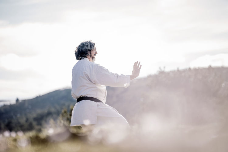 Senior man practicing karate outdoors