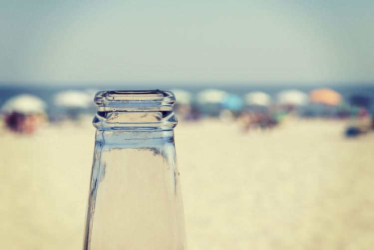 Close-up of drink on beach against sky