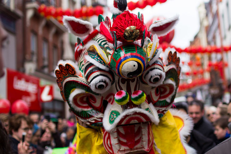 Close-up of dragon against crowds on street during chinese new year