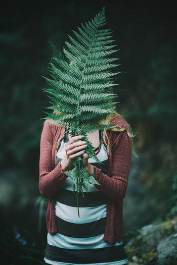Woman holding fern leaf