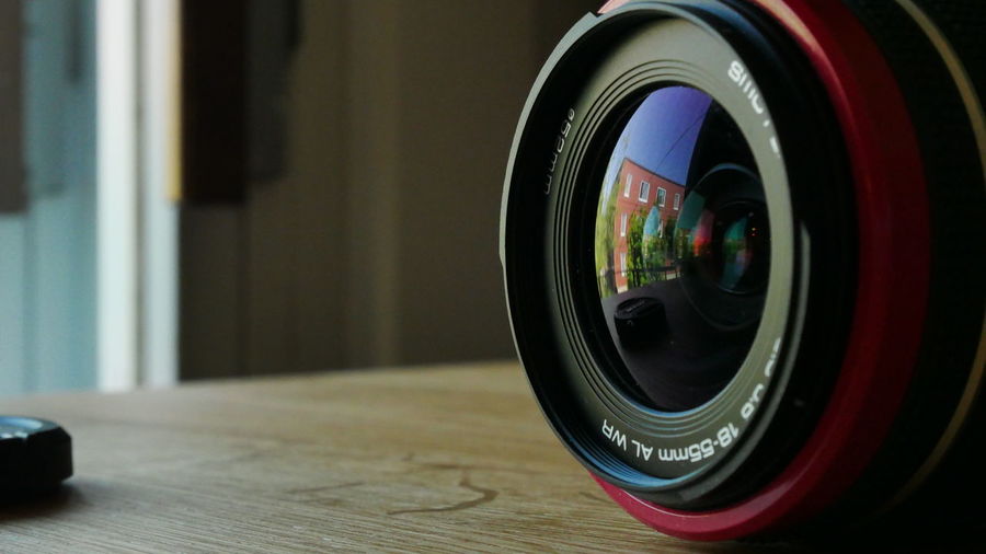 Close-up of camera lens on wooden table