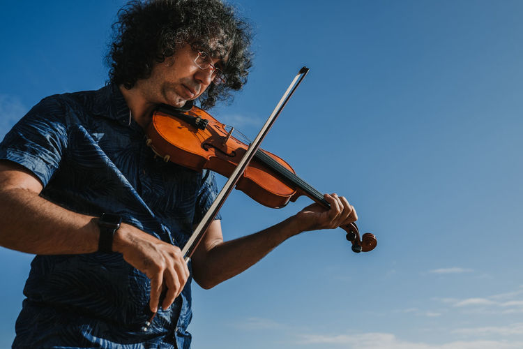 Man playing violin at beach
