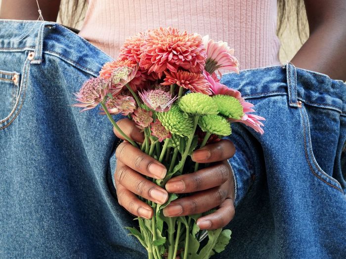 Midsection of woman holding flower bouquet