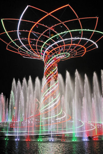 Low angle view of illuminated fountain against sky at night