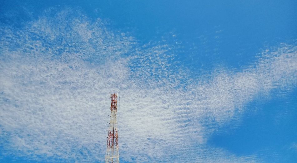 Low angle view of communications tower against sky on sunny day