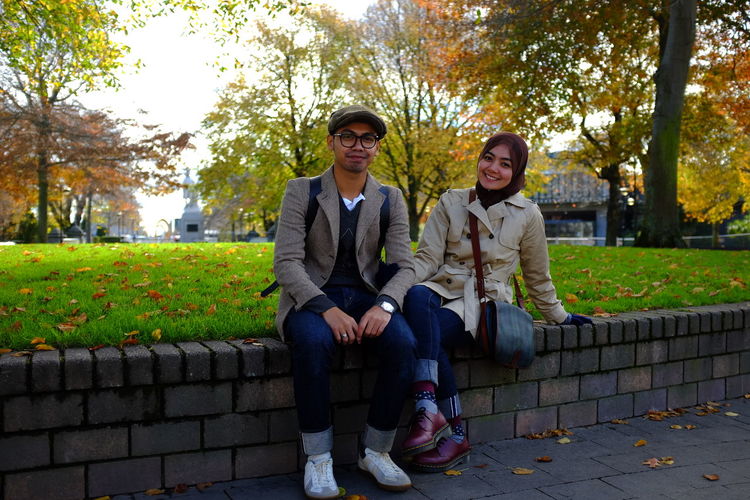 Portrait of couple smiling while sitting at park