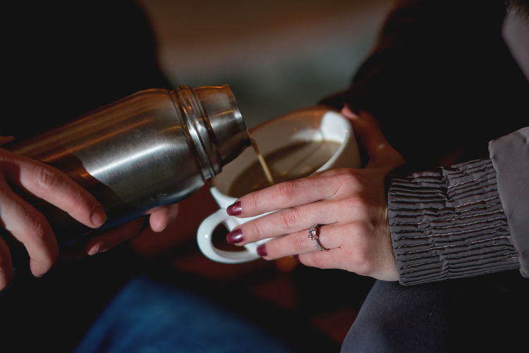 Midsection of couple having coffee at home