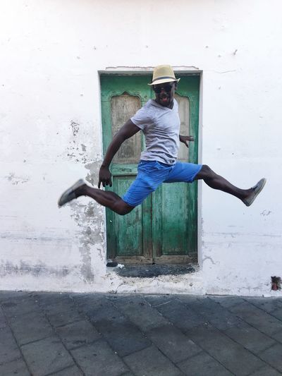 Full length of man jumping against closed door