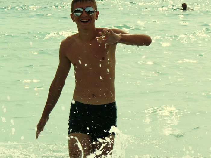 Happy shirtless man enjoying summer in sea