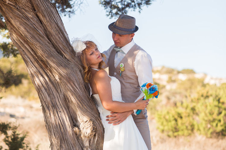 Side view of couple standing by tree