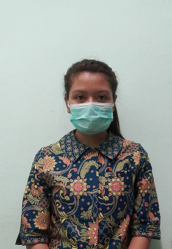 Portrait of woman standing against wall