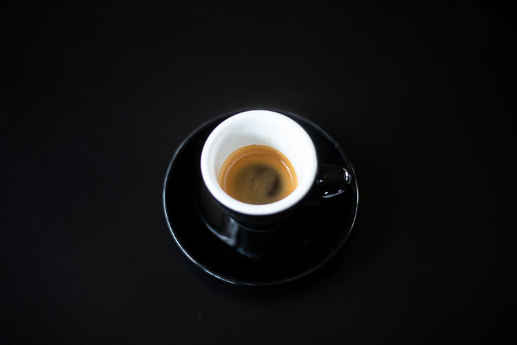 High angle view of coffee cup against black background