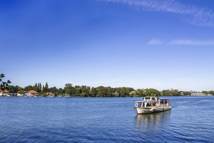 Boat sailing in sea against blue sky