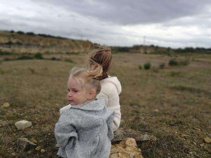 Mother and daughter sitting on field
