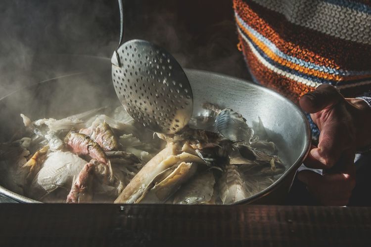 Full frame shot of man holding pan with cooked fish