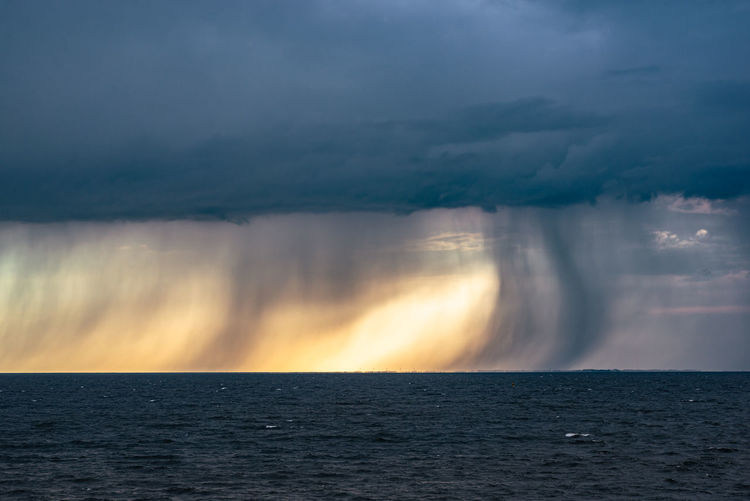 Dramatic view of fallstreaks of rain and hail below the base of a storm over lake ijsselmeer holland