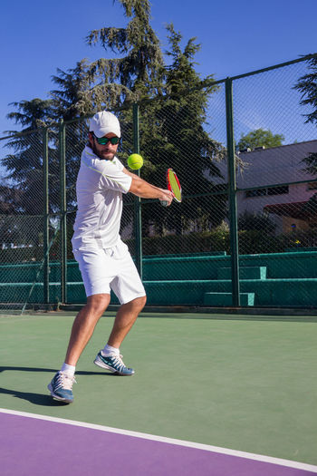 Man playing tennis at court