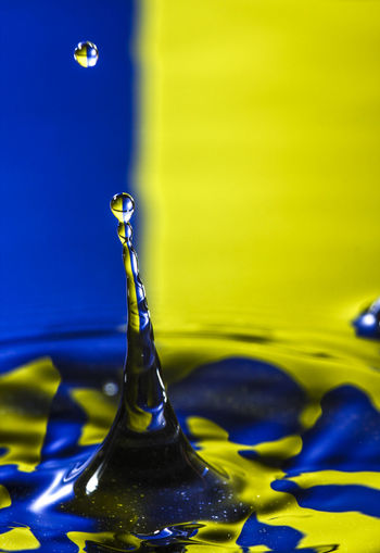 Close-up of droplet splashing on a liquid surface