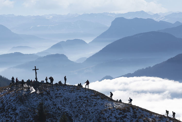 Border region austria germany, heuberg, silhouettes of backpackers hiking to mountain peak