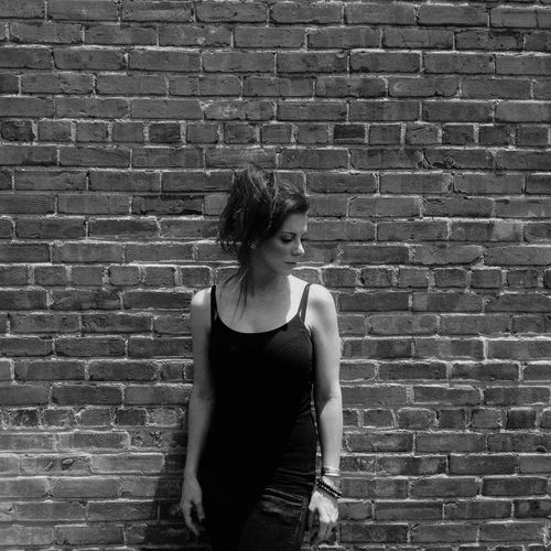 Young woman on brick wall
