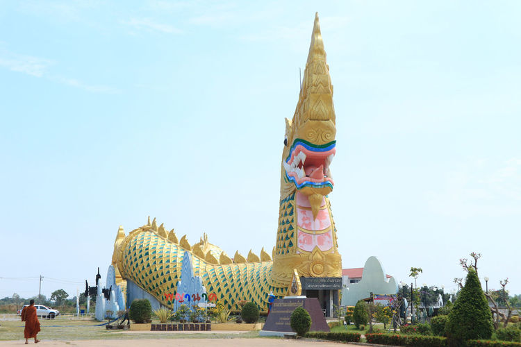 Panoramic view of statue outside building against sky