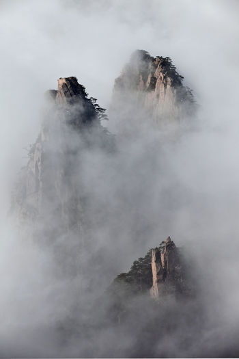 Scenic view of rocky mountains during foggy weather