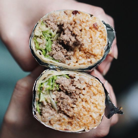 Cropped hands holding burrito