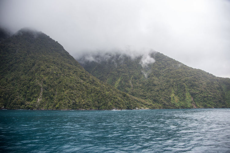 Scenic view of sea and mountains against sky