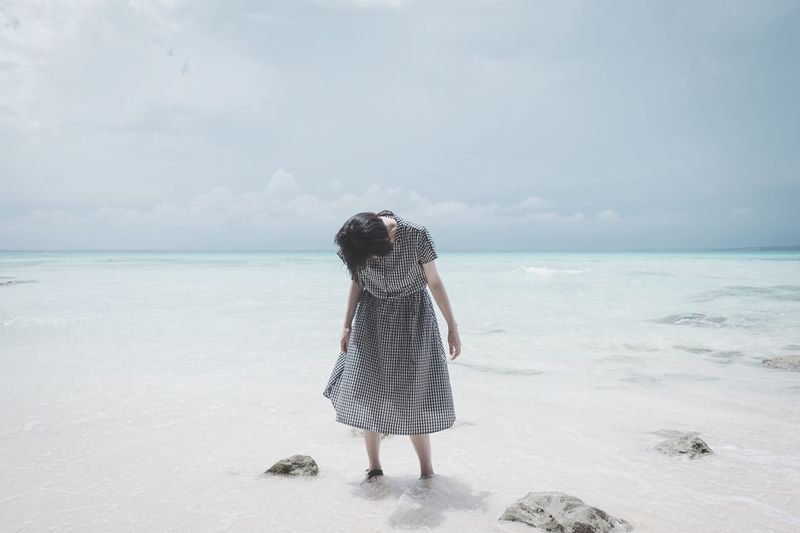 Rear view of woman standing on beach