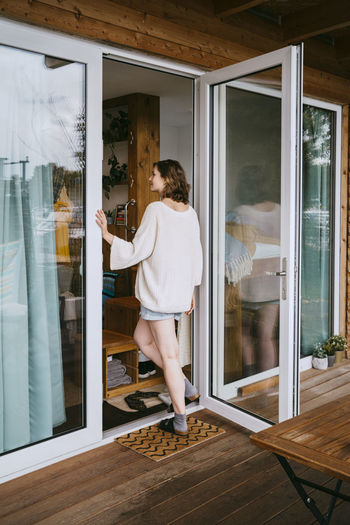 Rear view of young woman entering in tiny house