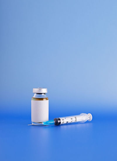 Close-up of glass bottle on table against blue background