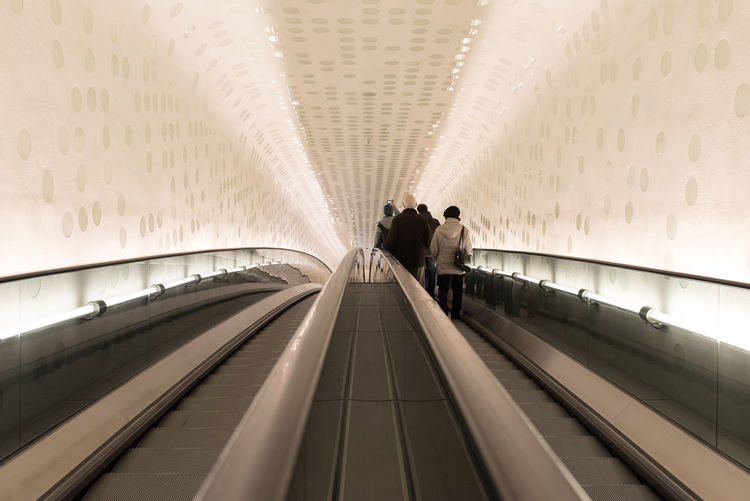 Rear view of people on escalator