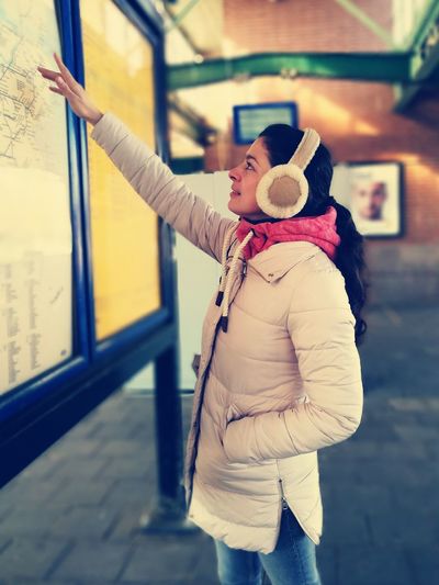 Side view of woman looking at map at station