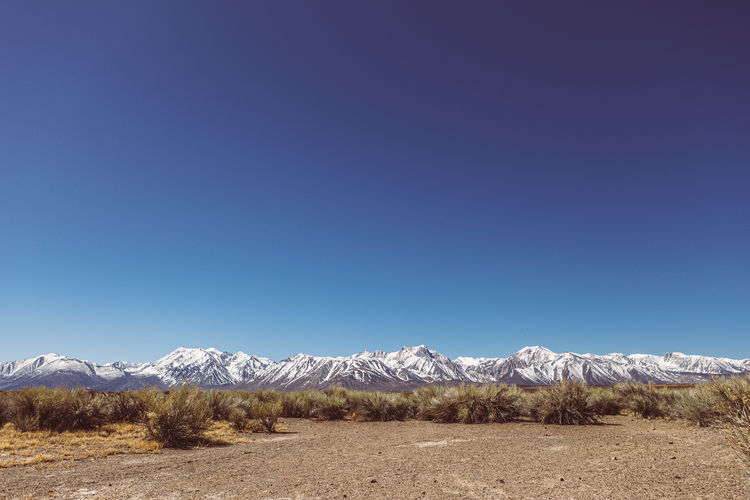 Scenic view of snowcapped mountains against clear blue sky