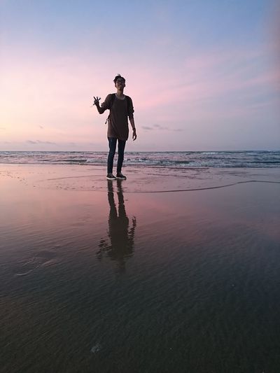 Full length of man standing at beach during sunset