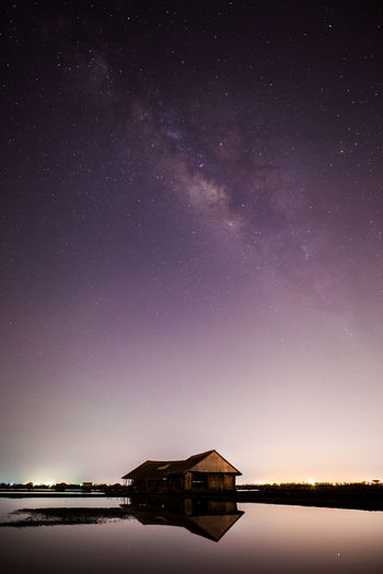 Scenic view of lake against sky at night