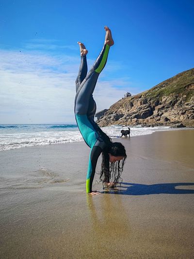Full length of woman doing a handstand on the beach 