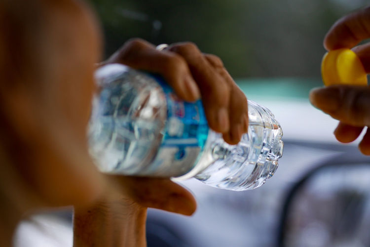 Close-up of person drinking water from bottle