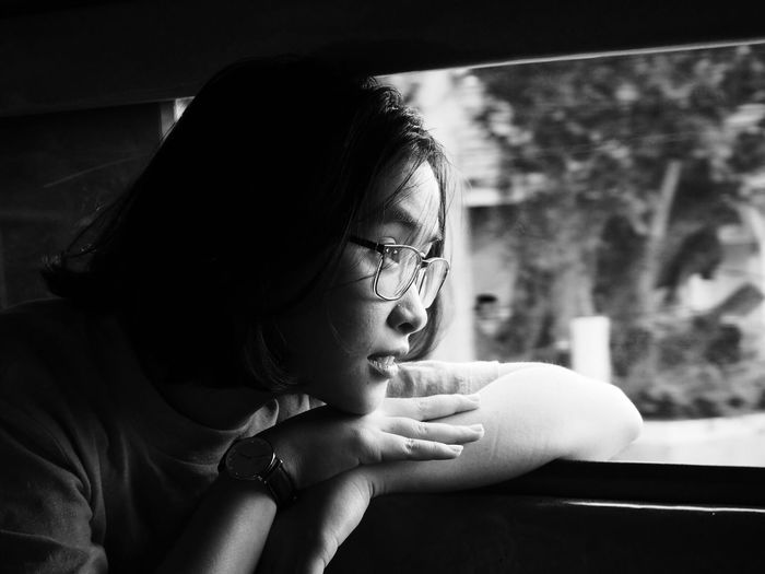 Woman looking through window while traveling in vehicle