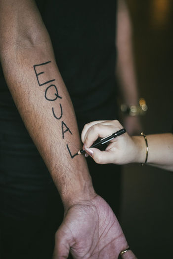 Female activist writing on man's hand for social issues