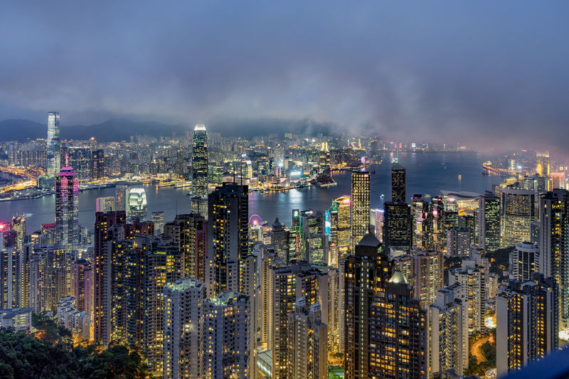 Illuminated cityscape against sky at night