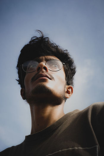 Low angle view of young man against sky